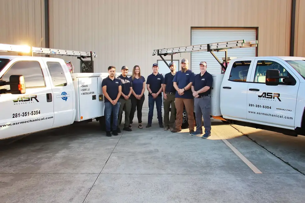 ASR Mechanical crew in navy polos between two liveried service trucks